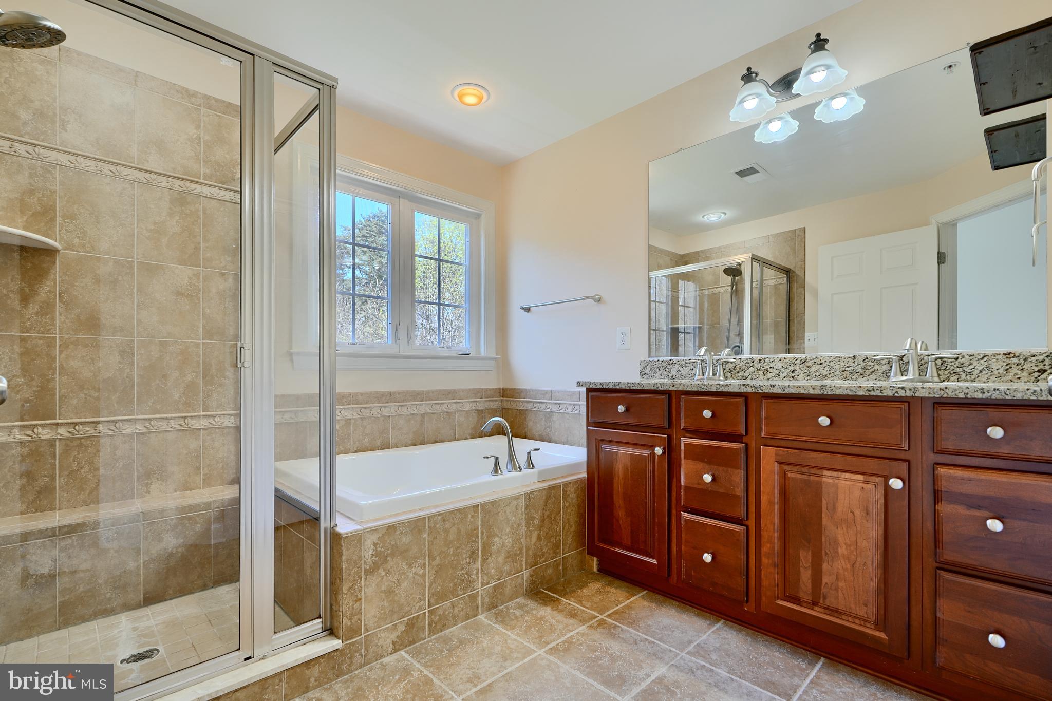 7570 Maidenhead Drive Hanover, MD 21076 - Photo 16 of 37 a bath room with a sink a vanity a mirror and a bathtub
