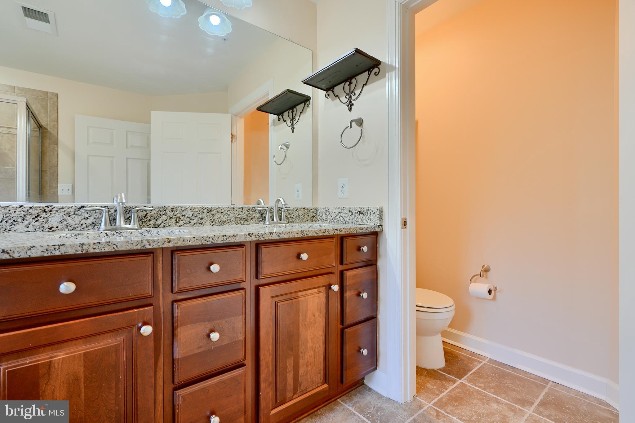 7570 Maidenhead Drive Hanover, MD 21076 - Photo 18 of 37 a bathroom with a granite countertop sink a toilet and a mirror