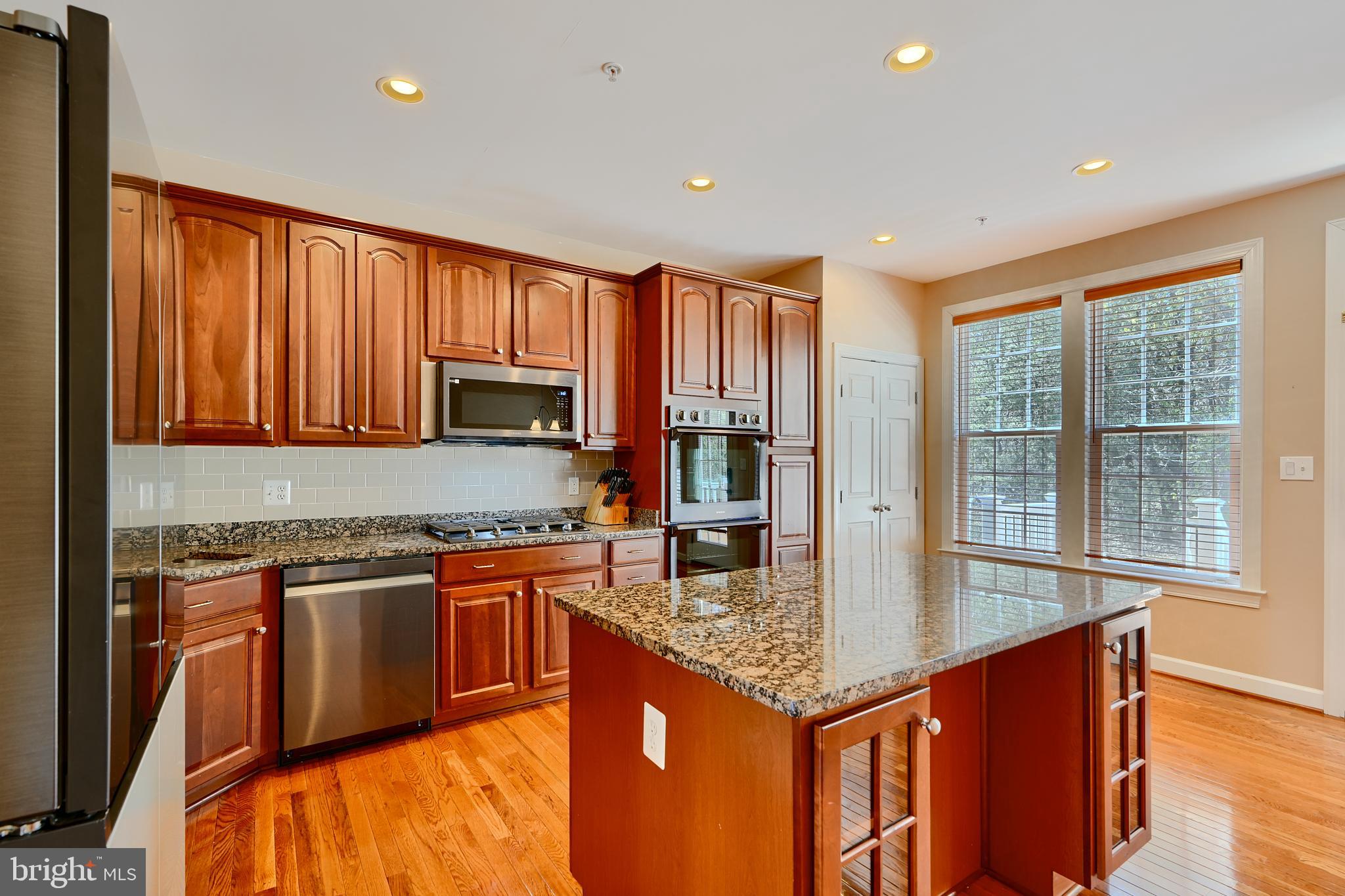 7570 Maidenhead Drive Hanover, MD 21076 - Photo 3 of 37 a kitchen with stainless steel appliances granite countertop a stove a sink dishwasher and a refrigerator with wooden floor