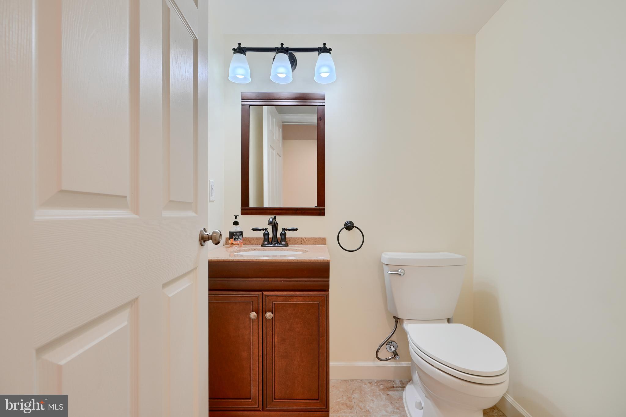 7570 Maidenhead Drive Hanover, MD 21076 - Photo 32 of 37 a bathroom with a toilet a sink and mirror