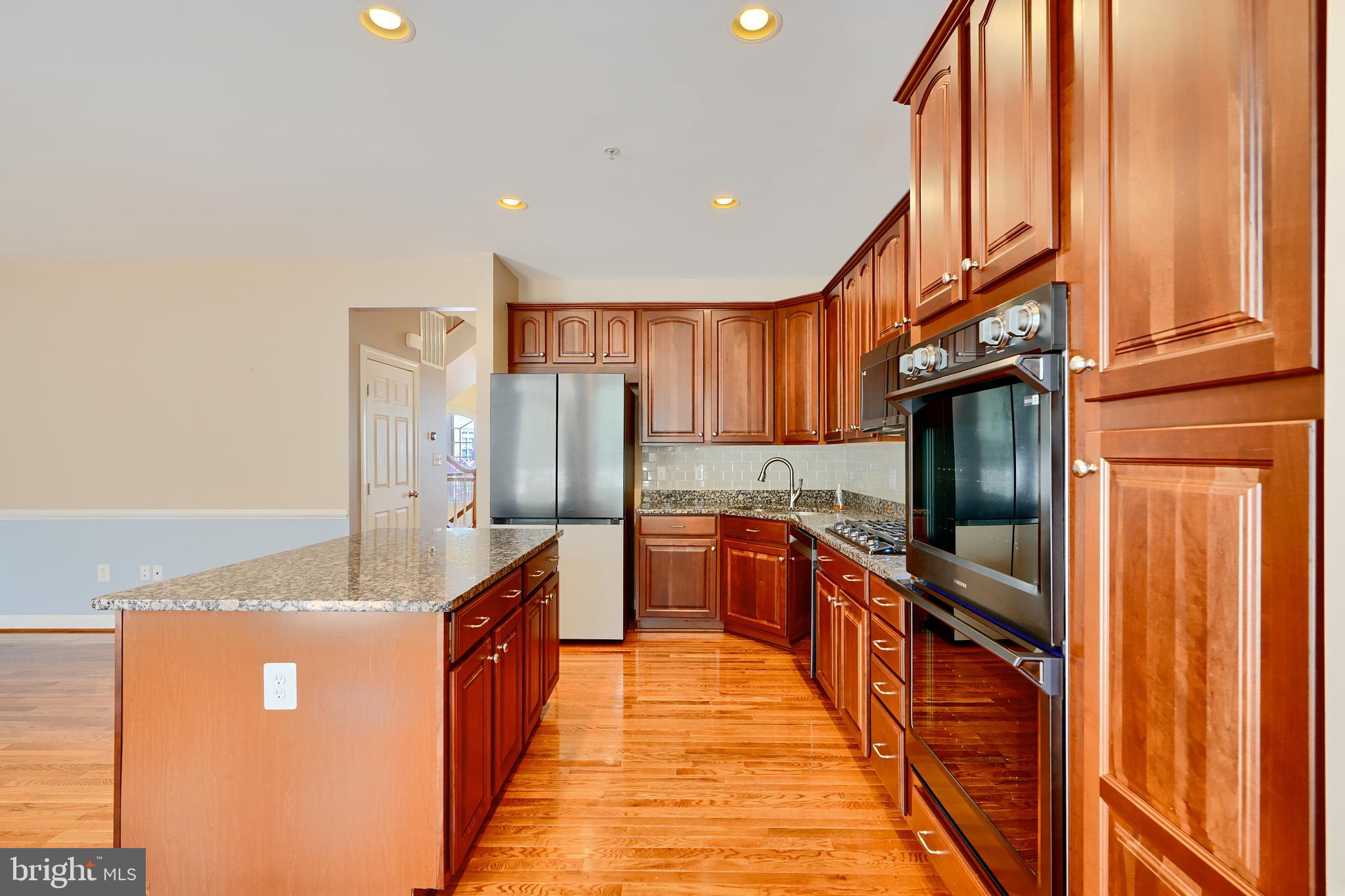 7570 Maidenhead Drive Hanover, MD 21076 - Photo 5 of 37 a large kitchen with stainless steel appliances granite countertop a refrigerator a stove and a sink
