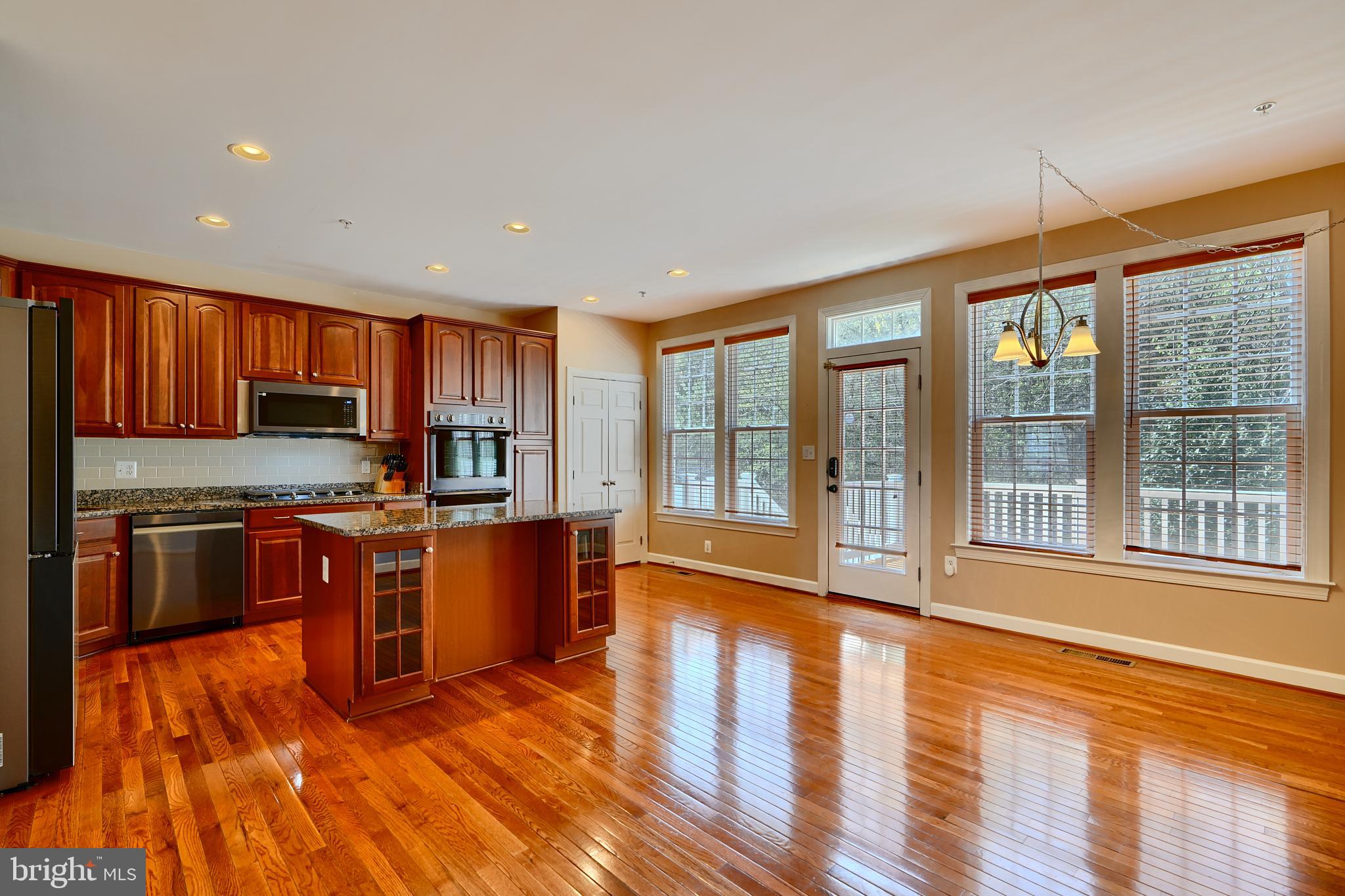 7570 Maidenhead Drive Hanover, MD 21076 - Photo 7 of 37 a kitchen with stainless steel appliances granite countertop a stove top oven a sink dishwasher a refrigerator and wooden cabinets with wooden floor