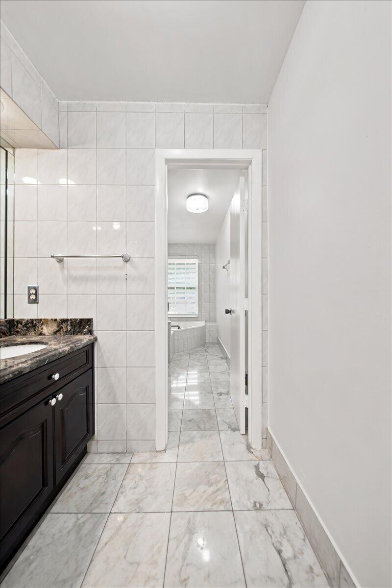 20009 Northwest 66th Place Hialeah, FL 33015 - Photo 19 of 33 a spacious bathroom with a granite countertop sink a mirror and a shower