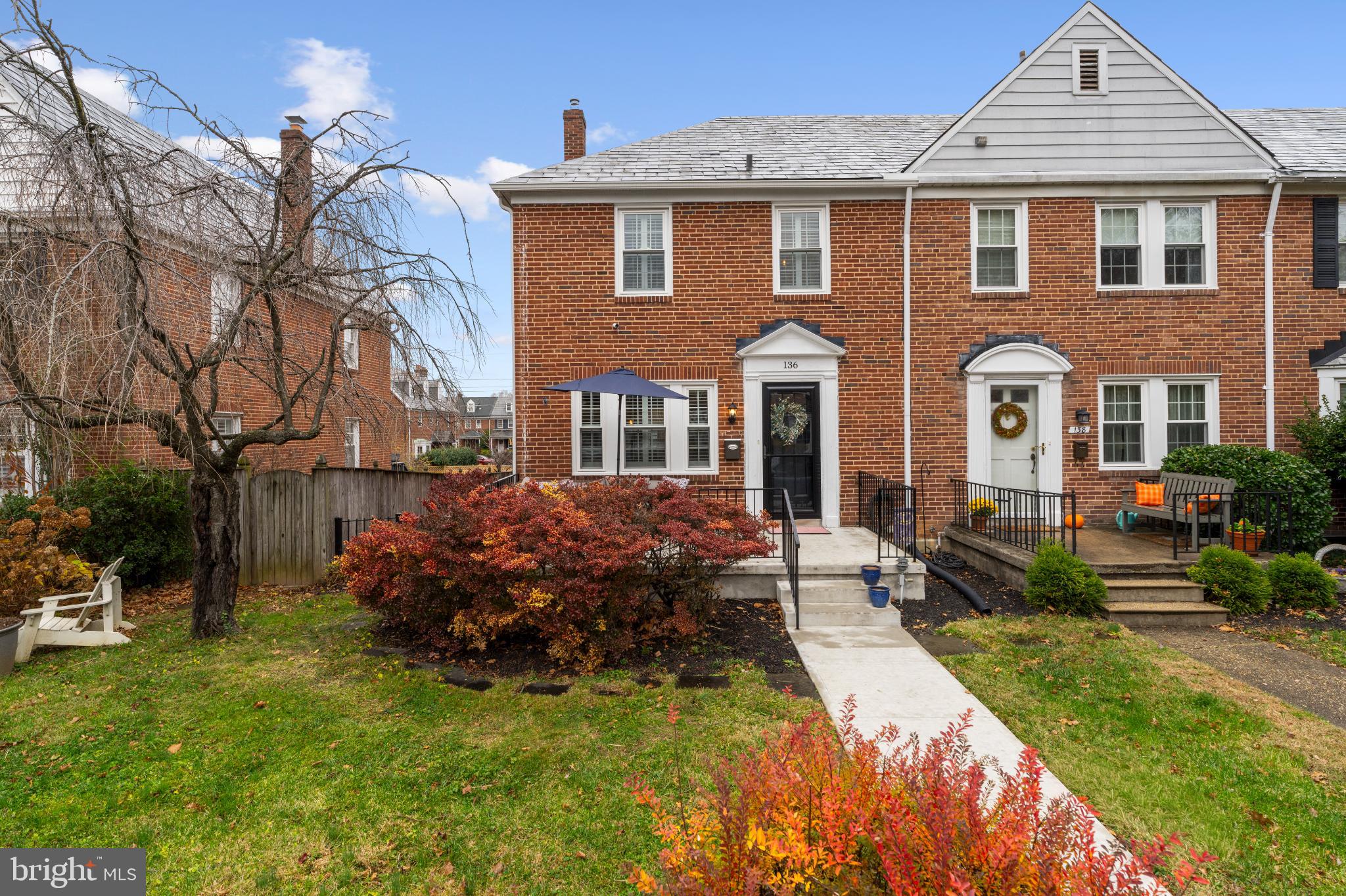 Charming brick townhouse with vibrant gardens.