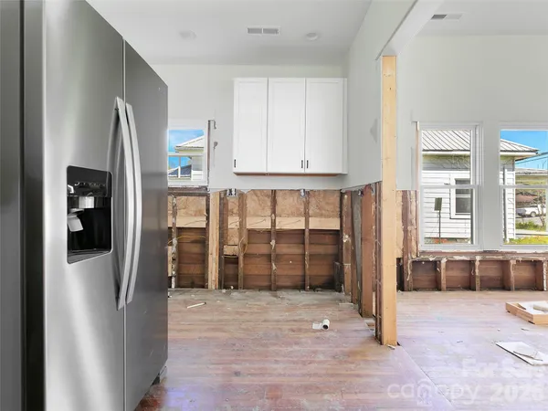 a view of a kitchen with refrigerator and windows