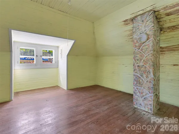 a view of a room with wooden floor and a hallway