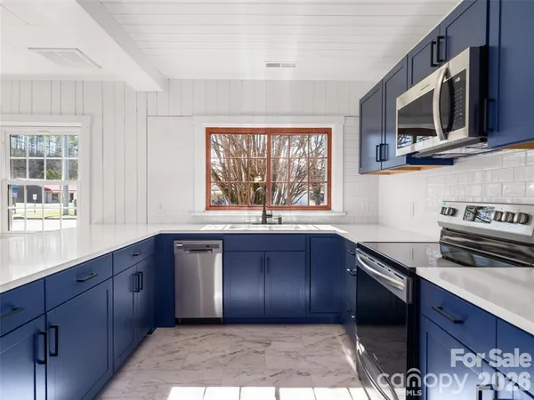 a kitchen with stainless steel appliances granite countertop a stove a sink and a microwave