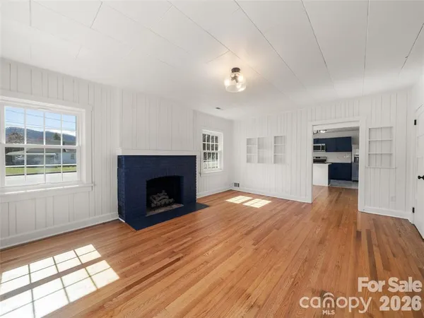 an empty room with windows and a fireplace