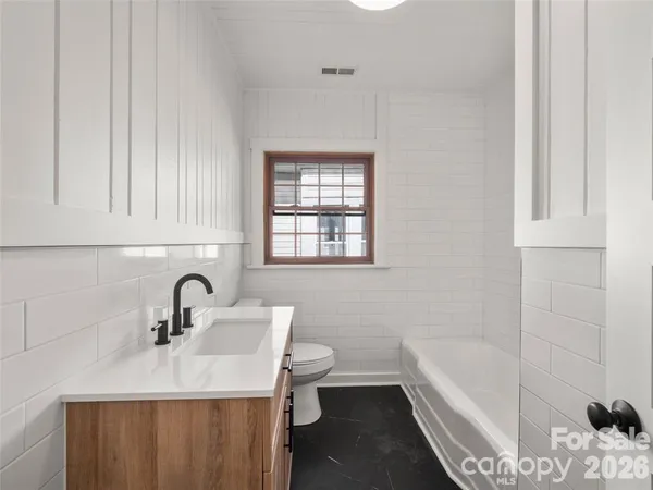 a bathroom with a sink a toilet and bathtub