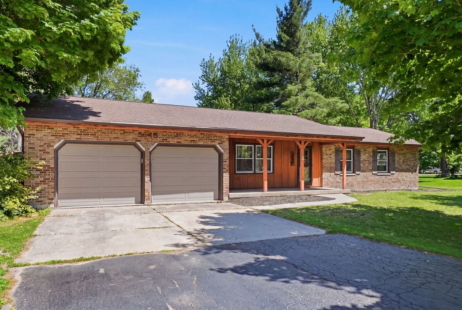 5645 Beebe Drive Rochelle, IL 61068 - Photo 4 of 43 a front view of a house with a garden and trees