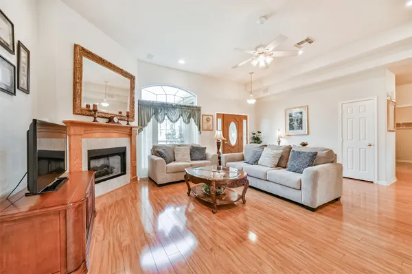 a kitchen with stainless steel appliances granite countertop a stove top oven a sink a dining table and chairs with wooden floor