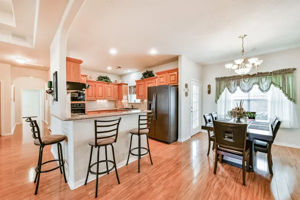 a view of a dining room with furniture a chandelier and wooden floor