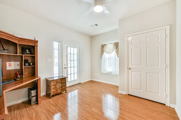 a view of a livingroom with wooden floor and a ceiling fan