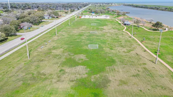 a swimming pool with lawn chairs and iron fence