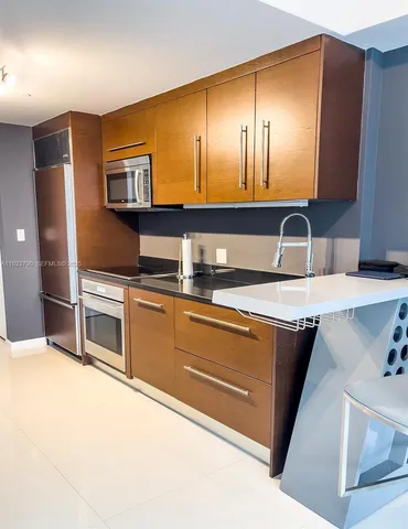a kitchen with stainless steel appliances granite countertop a sink and a stove top oven