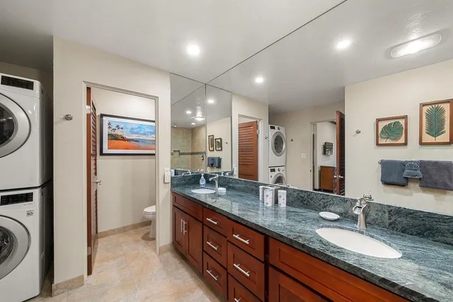 a bathroom with a granite countertop double vanity sink and a mirror