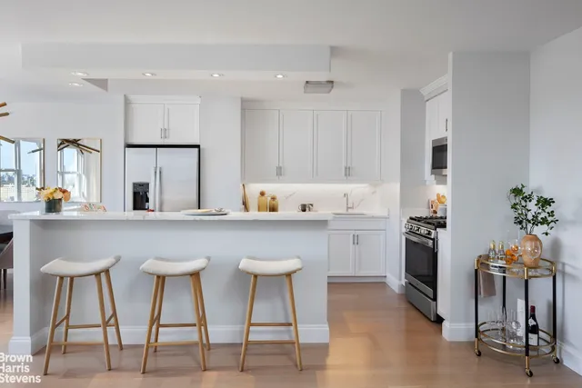 a kitchen with cabinets and chairs