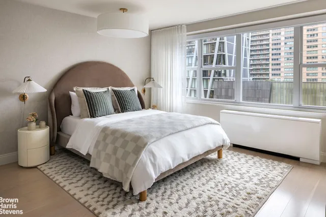 a bed sitting in a bedroom next to a window