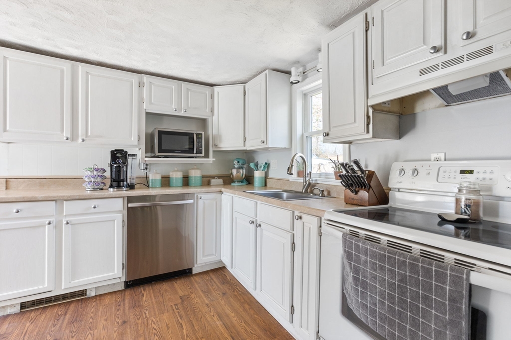 11 Mayflower Road Norton, MA 02766 - Photo 17 of 22 a kitchen with stainless steel appliances granite countertop a sink a stove a microwave and cabinets