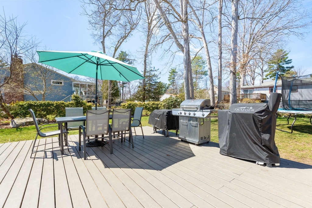 11 Mayflower Road Norton, MA 02766 - Photo 18 of 22 a view of a patio with table and chairs under an umbrella with wooden floor