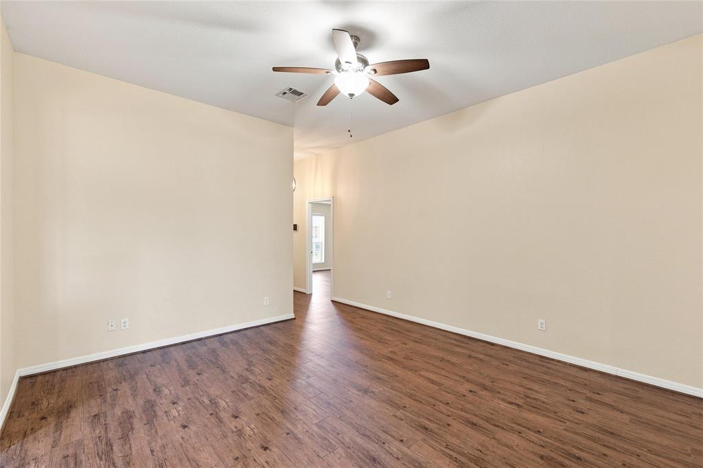 Wood-finish flooring with light-toned walls and a ceiling-mounted fan with integrated lighting