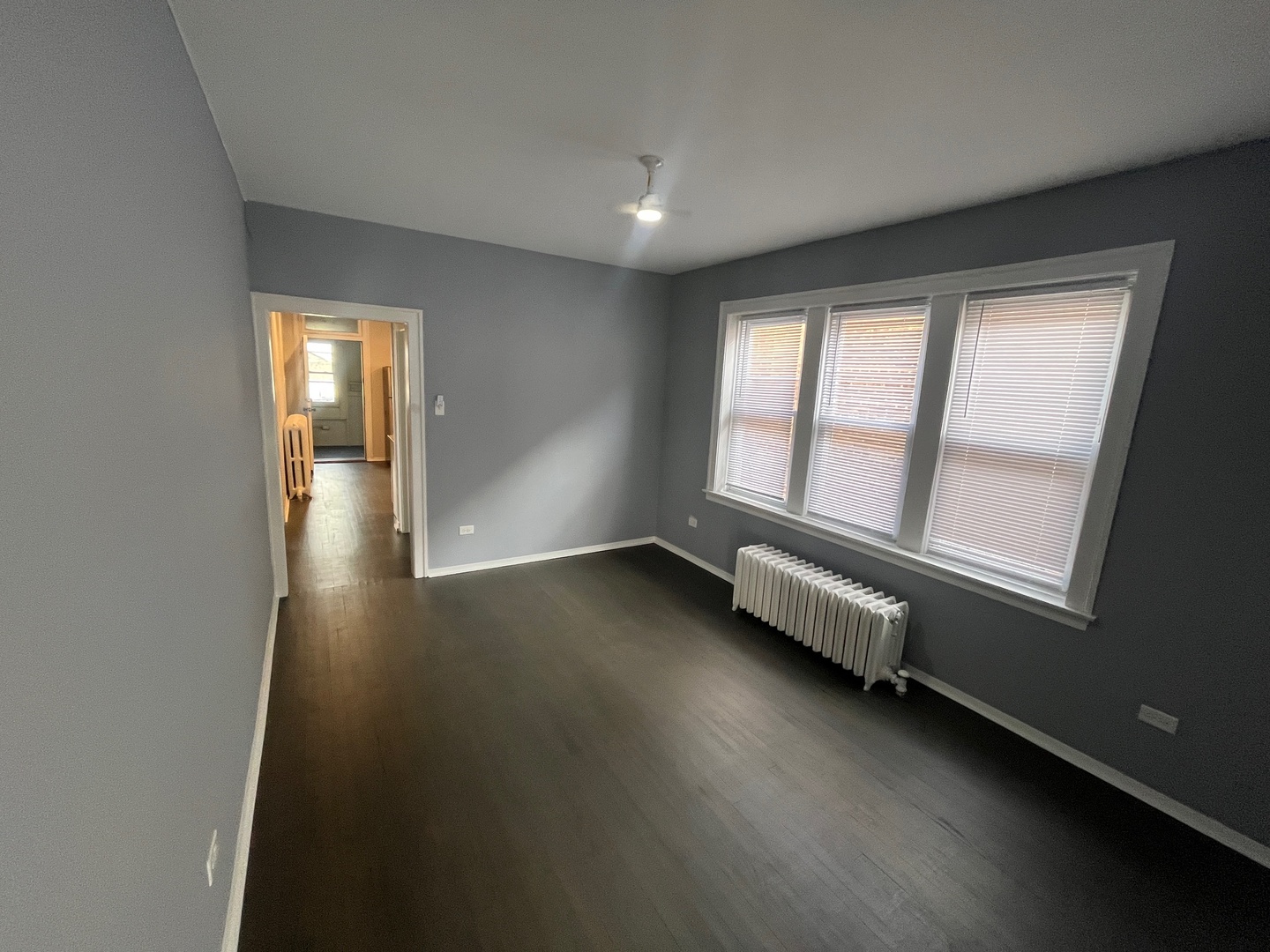 5115 South California Avenue, Unit 1 Chicago, IL 60632 - Photo 4 of 13 an empty room with wooden floor and windows