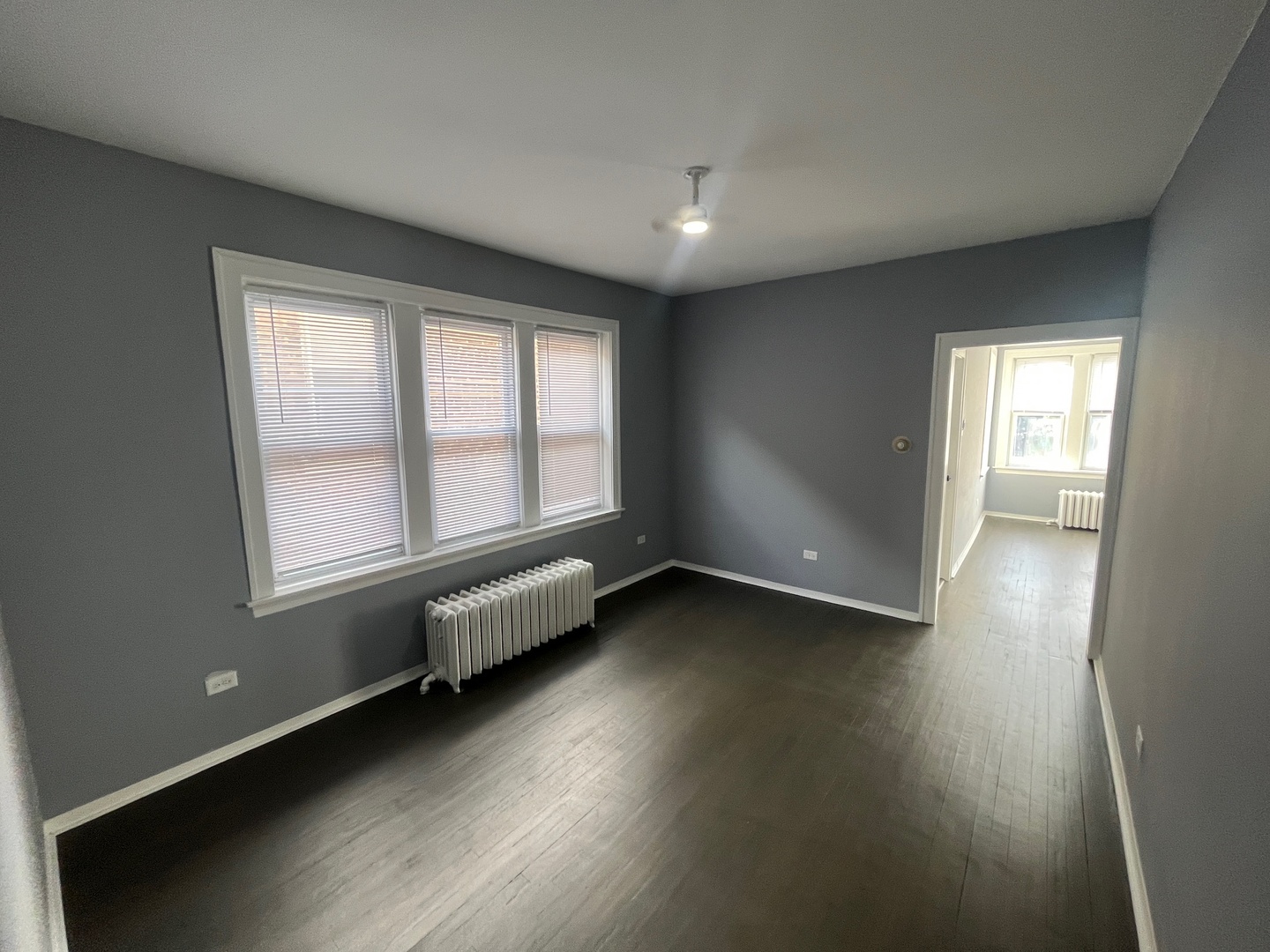 5115 South California Avenue, Unit 1 Chicago, IL 60632 - Photo 5 of 13 an empty room with wooden floor and windows