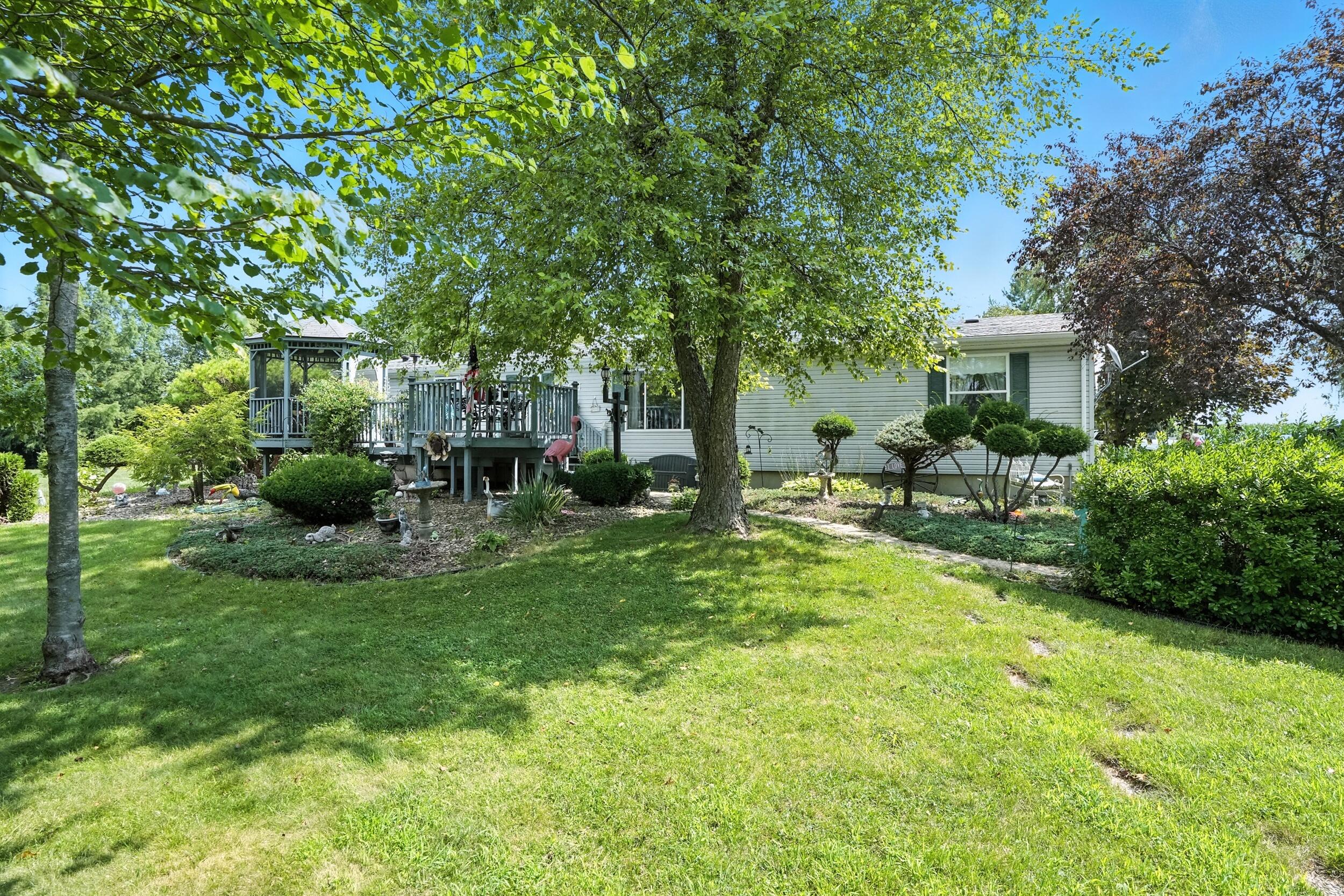 15338 Harrison Street Crown Point, IN 46307 - Photo 24 of 32 a view of a house with backyard sitting area and garden