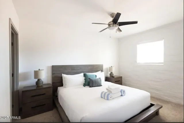 a bed sitting in a bedroom next to a window