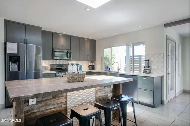 a kitchen with a table chairs refrigerator and cabinets