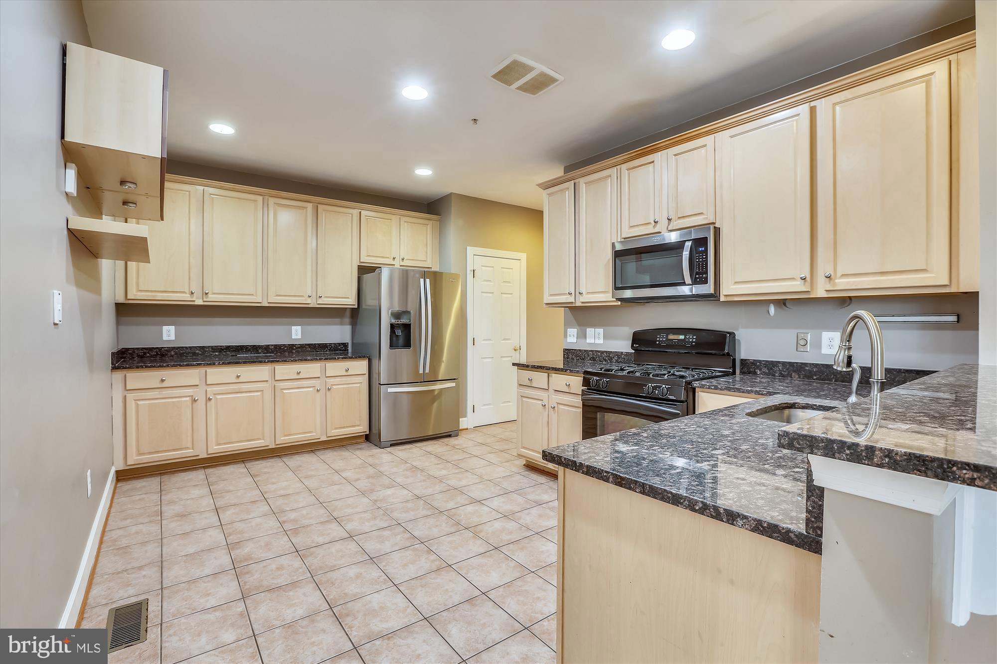 1004 Gaither Road Rockville, MD 20850 - Photo 12 of 34 a kitchen with granite countertop a stove sink microwave and refrigerator