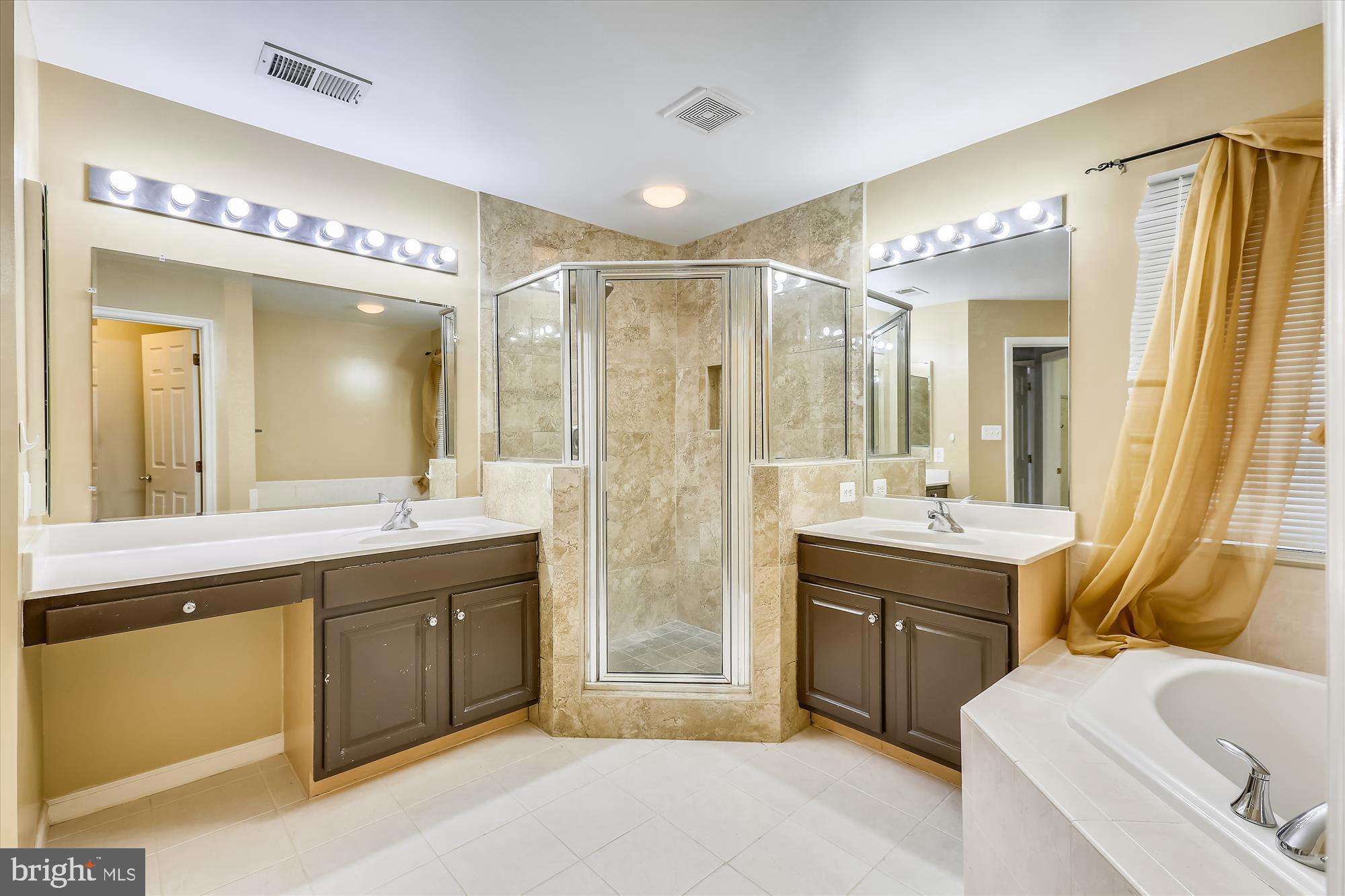 1004 Gaither Road Rockville, MD 20850 - Photo 16 of 34 a spacious bathroom with a double vanity sink mirror and a bath tub