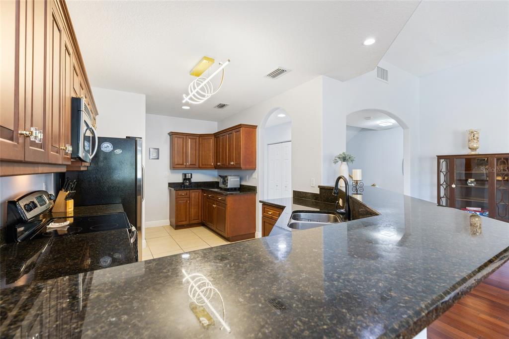 141 175th Avenue East Redington Shores, FL 33708 - Photo 13 of 51 a kitchen with stainless steel appliances granite countertop a sink a stove and a refrigerator