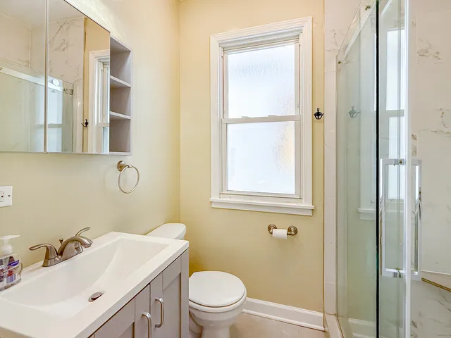 a bathroom with a sink a toilet and shower