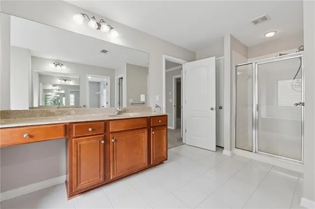 a spacious bathroom with a granite countertop sink mirror and shower