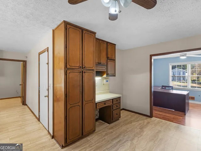a view of a hallway with wooden floor and chandelier