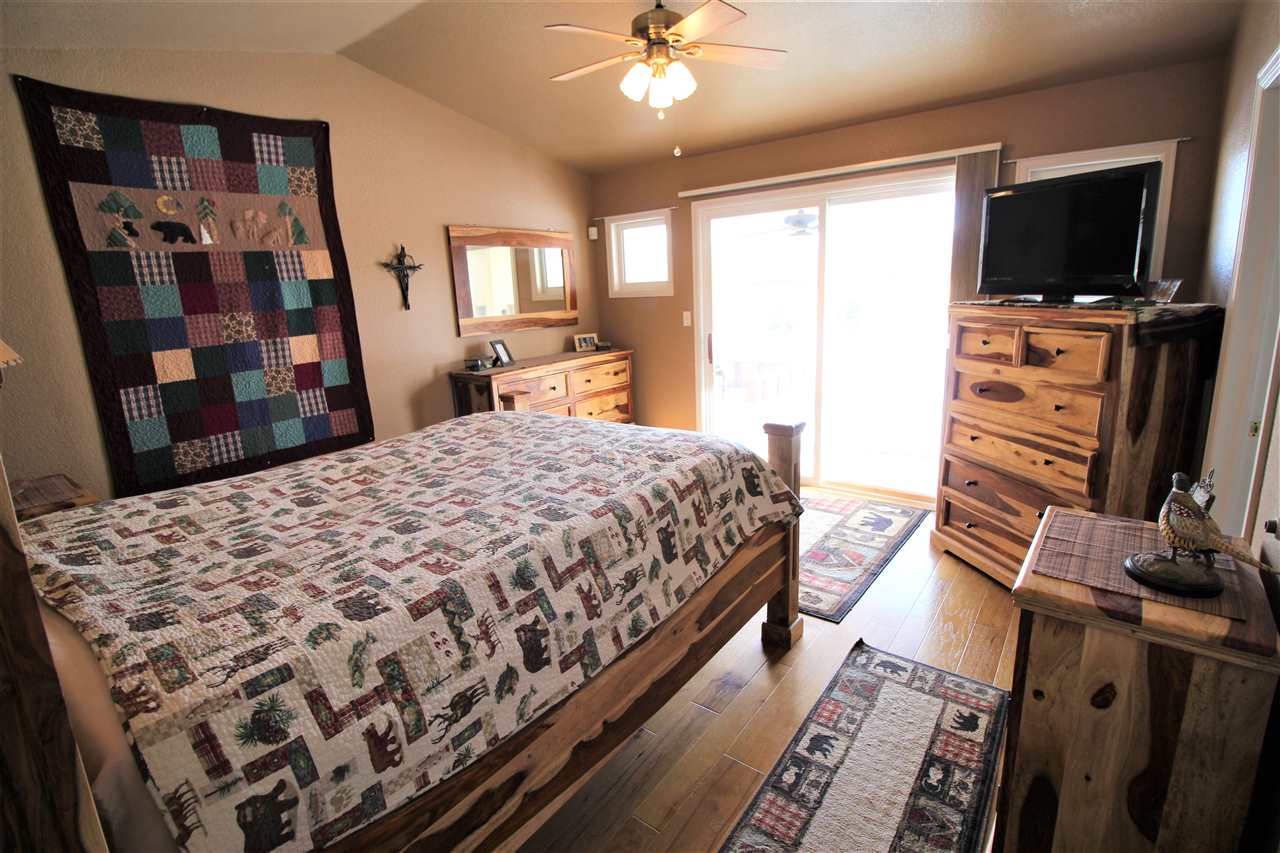 3455 F Road Clifton, CO 81520 - Photo 14 of 29 a bedroom with a large bed and a flat tv screen