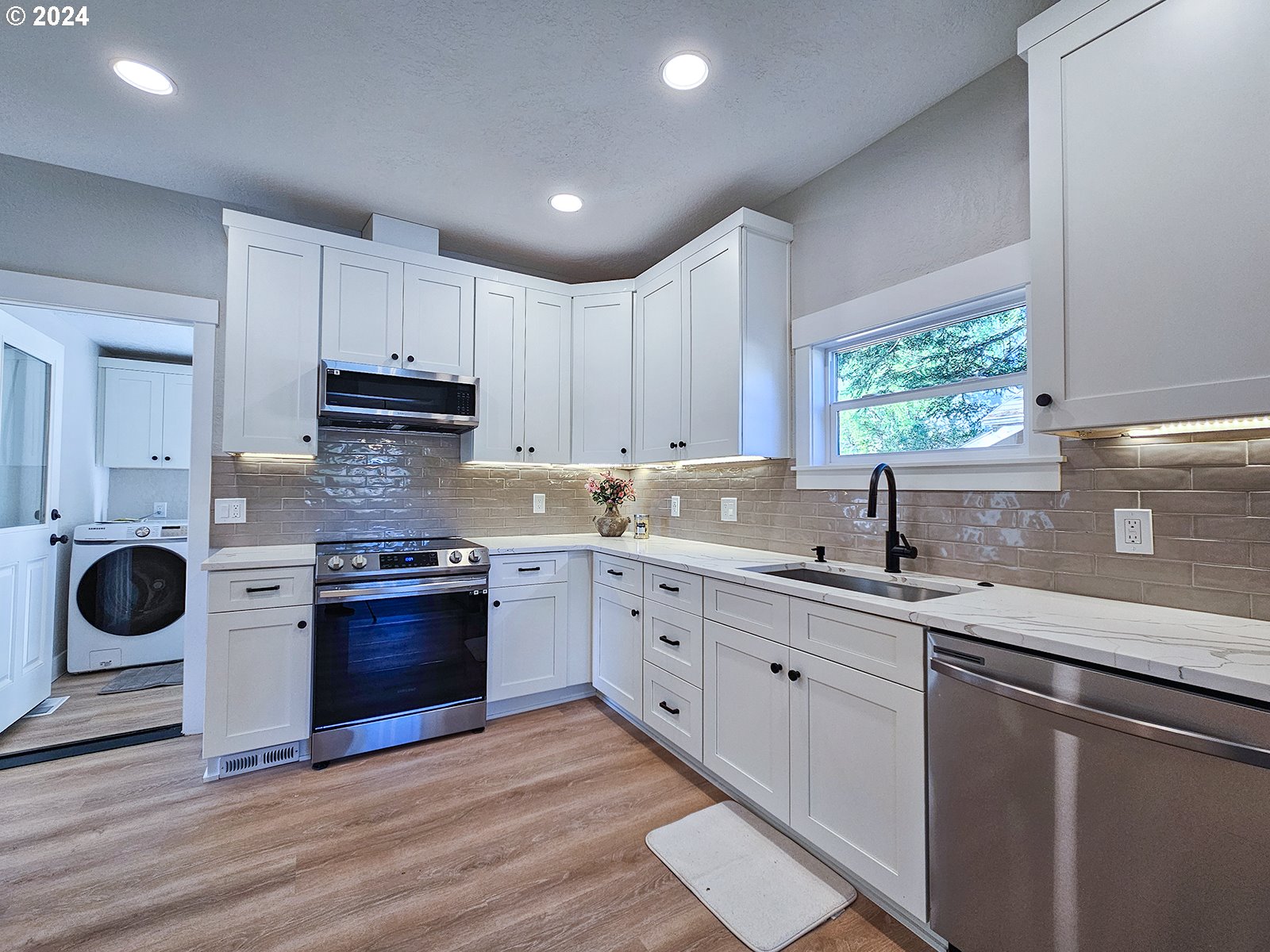 1532 Northeast Morgan Street Portland, OR 97211 - Photo 16 of 35 a kitchen with stainless steel appliances granite countertop a sink stove refrigerator and cabinets