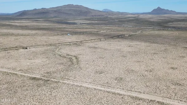 a view of a dry yard with mountain view