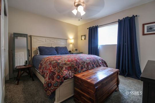 708 West Perdew Avenue Ridgecrest, CA 93555 - Photo 16 of 37 a bedroom with a bed window and a chandelier