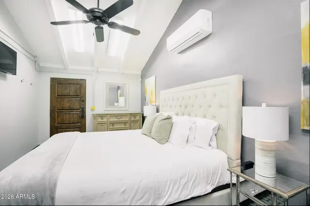 a bedroom with a bed and a lamp on the dresser