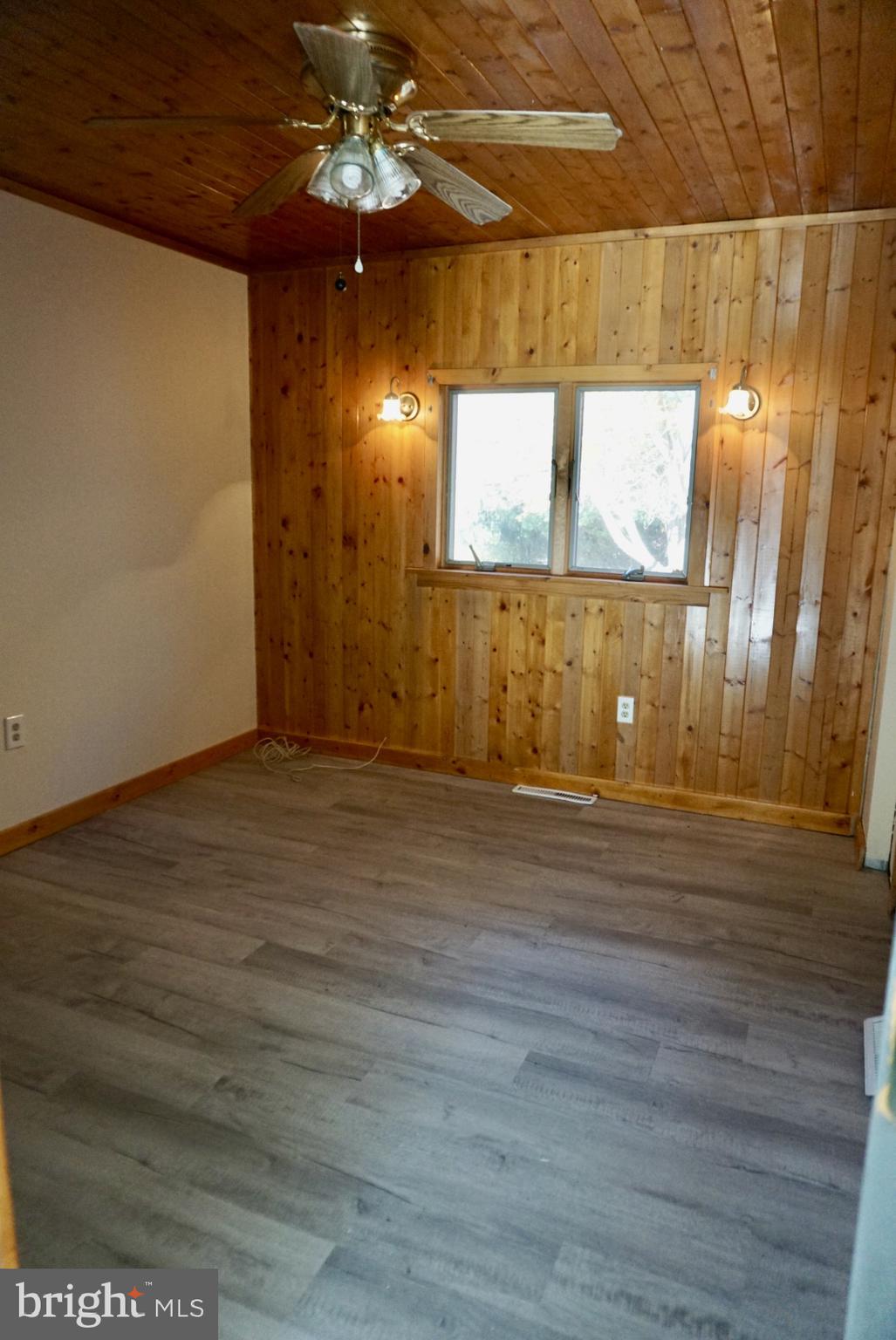 642 Stow Creek Road Bridgeton, NJ 08302 - Photo 6 of 25 a view of a room with wooden floor and a ceiling fan