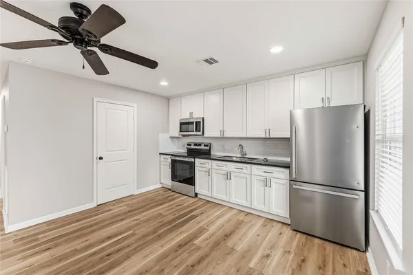 a kitchen with stainless steel appliances granite countertop a stove cabinets and a refrigerator