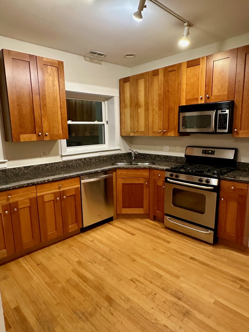 2537.5 Prairie Avenue, Unit 3S Evanston, IL 60201 - Photo 3 of 8 a kitchen with stainless steel appliances granite countertop wooden cabinets a stove top oven a sink and dishwasher