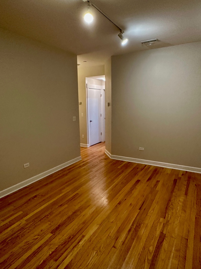 2537.5 Prairie Avenue, Unit 3S Evanston, IL 60201 - Photo 5 of 8 an empty room with wooden floor and windows