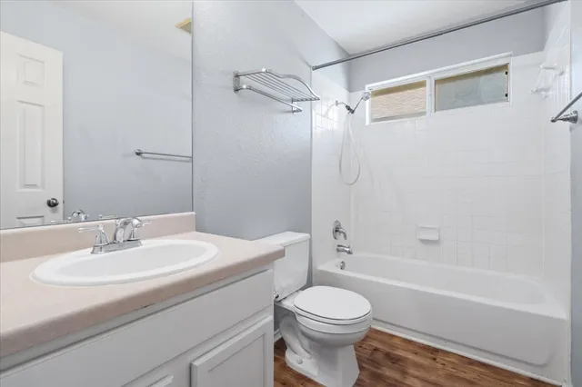 a view of a livingroom with a chandelier fan and wooden floor