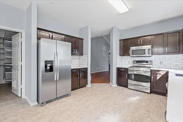 a kitchen with stainless steel appliances a stove a refrigerator and a microwave