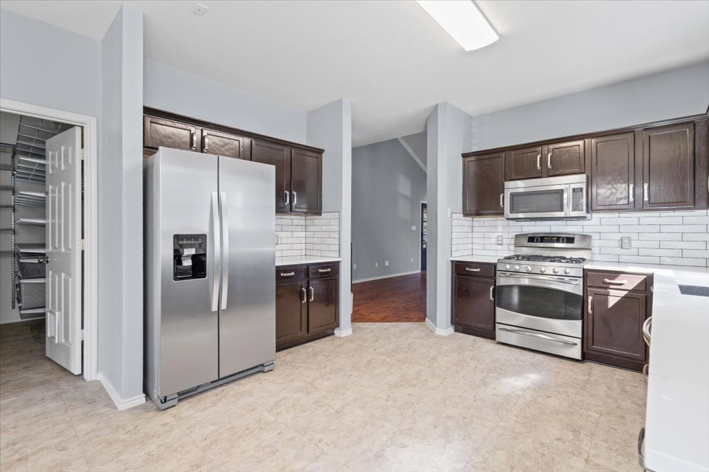 633 Fairway Kyle, TX 78640 - Photo 7 of 22 a kitchen with stainless steel appliances a stove a refrigerator and a microwave