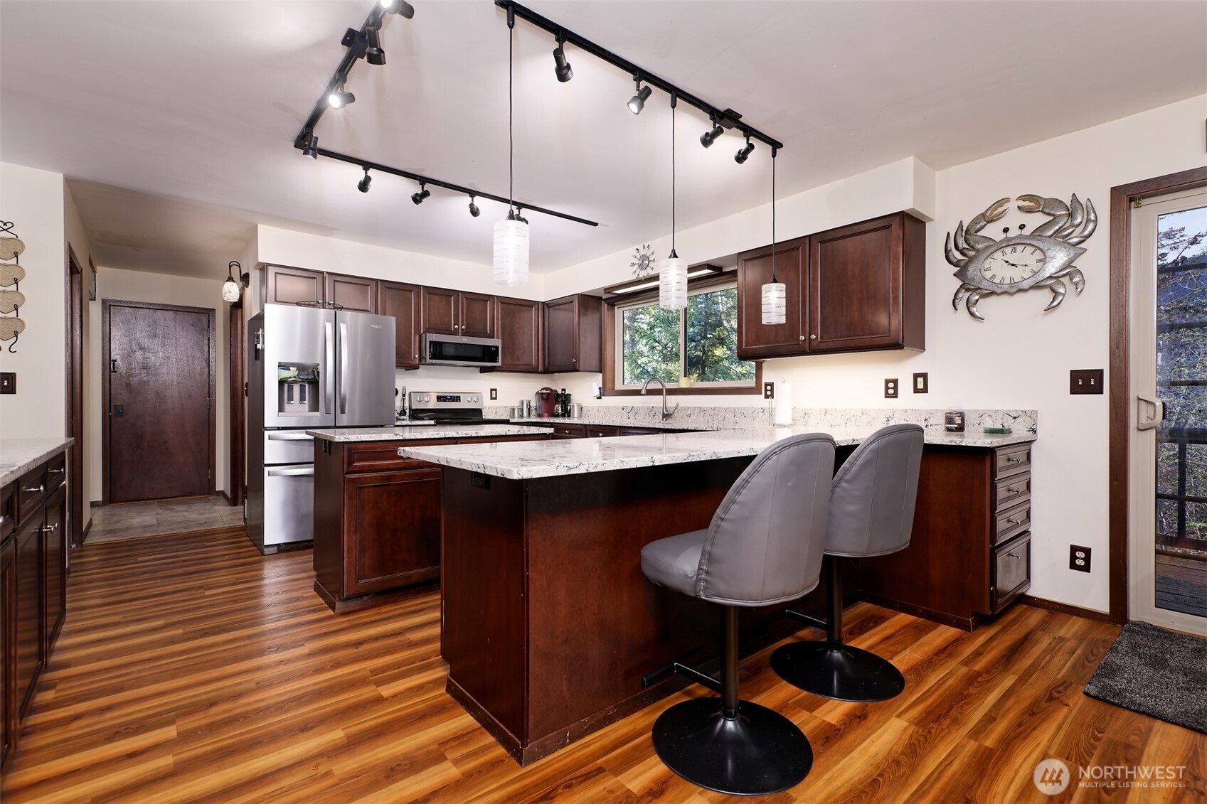 5791 North Lake Cushman Road Hoodsport, WA 98548 - Photo 13 of 39 a kitchen with stainless steel appliances kitchen island granite countertop a table chairs a refrigerator and a sink