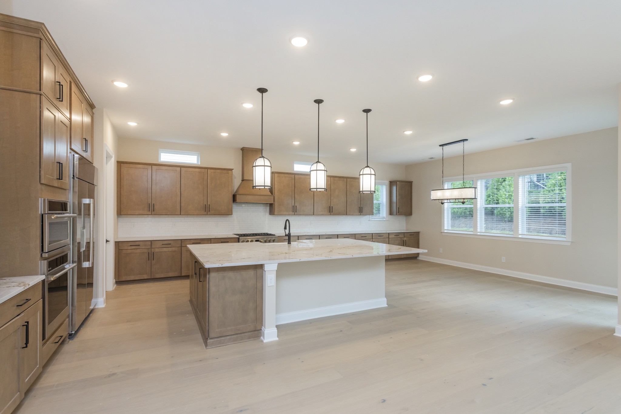 7006 Thunderhead Way Spring Hill, TN 37174 - Photo 17 of 58 a large kitchen with stainless steel appliances kitchen island a large counter top a stove and a sink